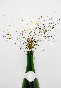 圣诞节，假日和庆祝概念香槟瓶和金色闪光在白色背景。香槟瓶和白色的金色闪光