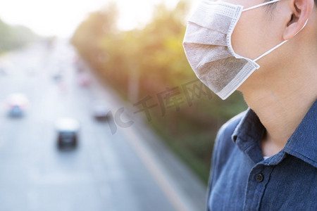口罩摄影照片_男子戴着口罩以防病毒。每次出门前