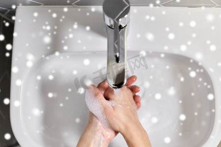 卫生，保健和安全概念—妇女用液体肥皂和雪洗手特写。特写妇女洗手用液体肥皂