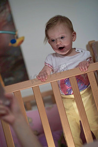 可爱的小一岁的婴儿玩玩具在床上，而使第一步和学习走路