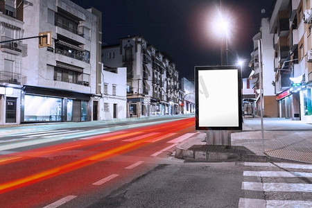 汽车光路经过附近的空白广告牌人行道城市。漂亮的照片。汽车轻径通过附近的空白广告牌人行道城市