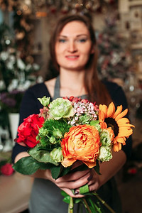 花店手拿花束五颜六色的花特写。模糊背景花店手拿花束花特写。