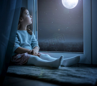 月亮卡通摄影照片_一个可爱的小kidl看在夜月亮的肖像