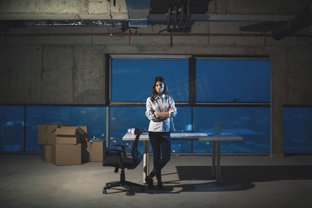 年轻女建筑师的肖像在建筑工地使用膝上型计算机检查文件和业务工作流程在新的启动办公室