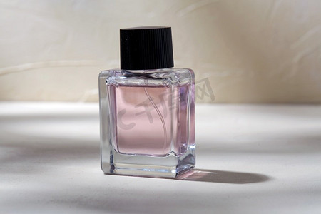 香水瓶三视图摄影照片_美丽，香水和对象概念—瓶香水在白色表面与阴影。香水瓶在白色表面与阴影
