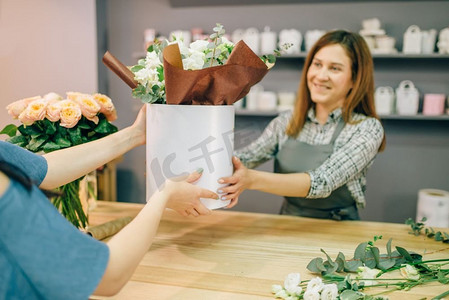 专卖店摄影照片_花店提供鲜花组合物在花瓶女性顾客在鲜花专卖店。花店内部在背景