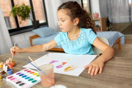 童年，爱好和休闲概念—小女孩在家里用颜色和画笔画画。小女孩与颜色绘画在家里