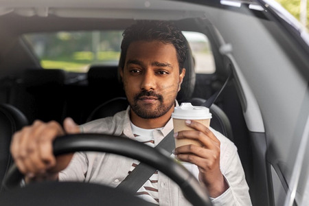 运输，车辆和人的概念—印度男子或司机与外卖咖啡杯驾驶汽车。印度男子或司机与咖啡驾驶汽车