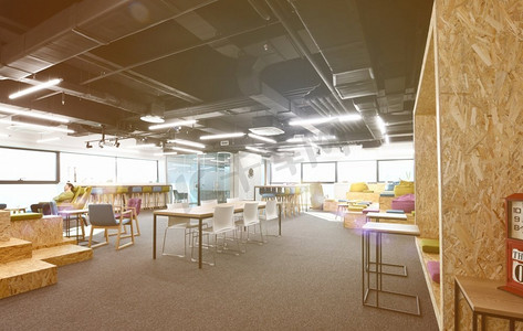 年轻的软件开发人员在现代阳光明媚的开放式办公室休闲区享受休息