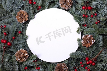 圆形圣诞边框摄影照片_天然冷杉圣诞树松果红冬青浆果，在白色孤立的圆形边框框架，文本复制空间。冷杉树枝框架在白色