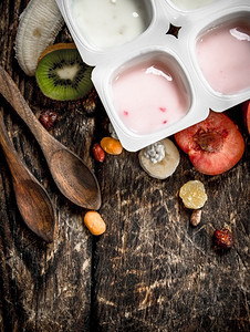 新鲜酸奶配水果和坚果。在一个木制的背景下。新鲜酸奶配水果和坚果。