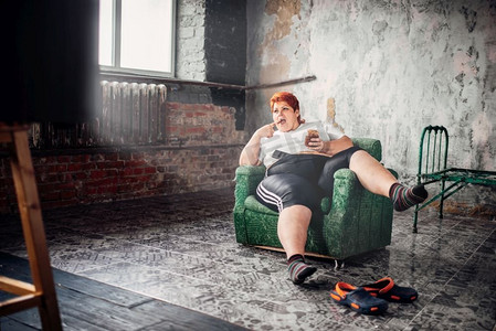 胖女人坐在椅子上吃糖果，超重。不健康的生活方式，肥胖。胖女人吃甜食、超重、肥胖