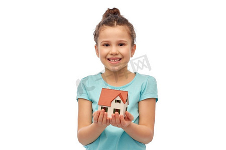 抵押贷款、房地产和住宿概念-微笑的女孩在白色背景下抱着房子模型。微笑的女孩抱着房子模特