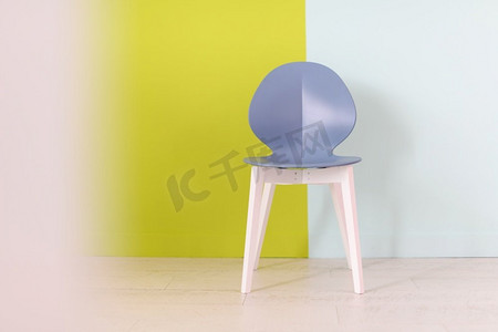 椅子创意摄影照片_现代蓝色椅子在一个蓝色绿色背景前面家装饰的概念