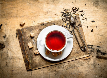 马克摄影照片_加蔗糖的浓味茶。在木制背景上。加蔗糖的浓味茶。