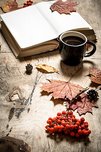 秋天的风格。打开一杯热咖啡。在木制背景上。秋天的风格。打开一杯热咖啡。
