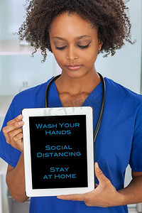 非裔美国黑人女医生在医院感染冠状病毒新冠肺炎在平板电脑上提出社交距离建议