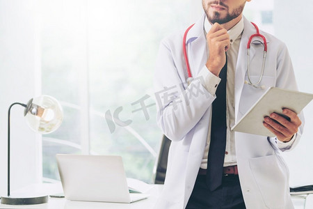 医生在医院的办公室工作在平板电脑上。医疗保健概念医生在医院工作的平板电脑。