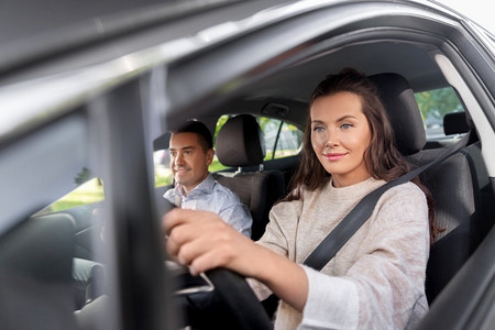驾驶员课程和人的概念—年轻妇女在驾驶学校的指导下学习驾驶汽车。女驾驶员和驾驶学校讲师