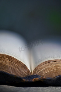 阅读桌摄影照片_一本古老的开放圣经在石桌地板上