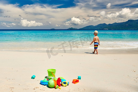 三岁的蹒跚学步的男孩在海滩上玩沙滩玩具。夏季家庭度假在塞舌尔，马埃岛。