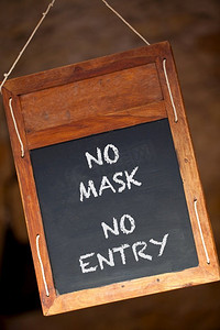 无口罩禁止入境冠状病毒COVID—19挂在零售商店、餐馆或咖啡馆的木黑板或黑板菜单标志