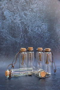 浪漫的老葡萄酒玻璃愿望瓶与好运气魅力在瓶里面有软木盖和古董效果背景