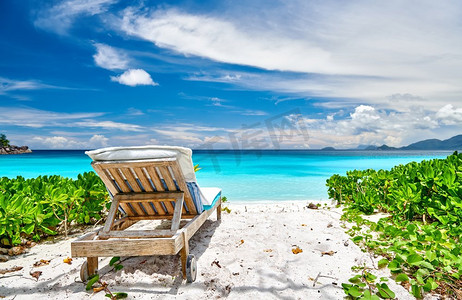 休闲的海滩摄影照片_美丽的Petite Anse海滩与日光浴床在塞舌尔，马埃岛