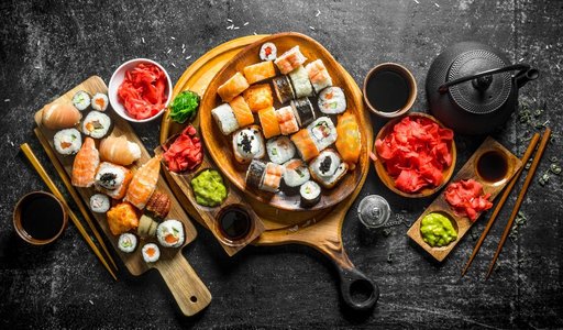 美食背景寿司摄影照片_将传统的日本寿司卷放在砧板上。乡村背景。将传统的日本寿司卷放在砧板上。