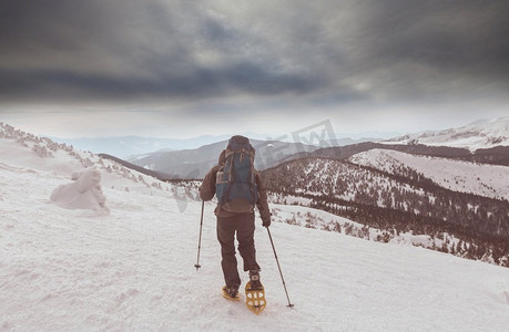 登山徒步的人摄影照片_冬季山区的徒步旅行者