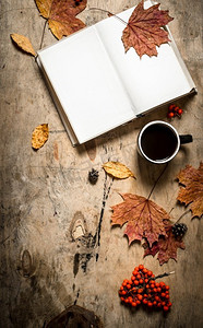 秋天的风格。打开一杯热咖啡。在木制背景上。秋天的风格。打开一杯热咖啡。