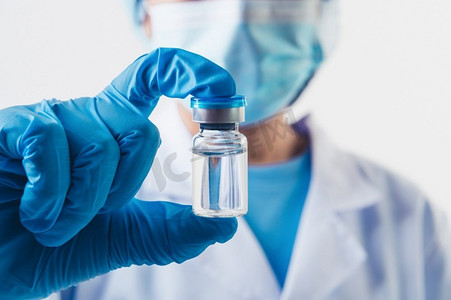 实验室专业科学家或医生手中拿着一小瓶 covid-19 疫苗,用白色背景的