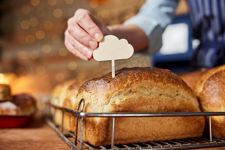 面包店销售助理将空白标签放入新鲜出炉的酸面团面包中