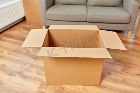 存储、移动和包装概念-新家的空瓦楞纸箱和沙发。新家的瓦楞纸箱和沙发是空的