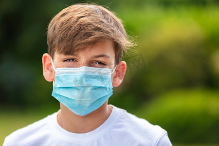 在冠状病毒新冠肺炎病毒大流行期间，十几岁的男孩在户外戴着口罩