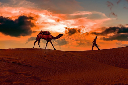 thar摄影照片_日落时分的骆驼，骆驼司机。在日落的塔尔沙漠Jaisalmer，拉贾斯坦邦，印度。