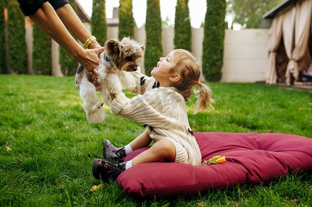 美女女孩靠近宠物玩具的鸭子脚印首饰带着小狗的小女孩睡在宠物店里.