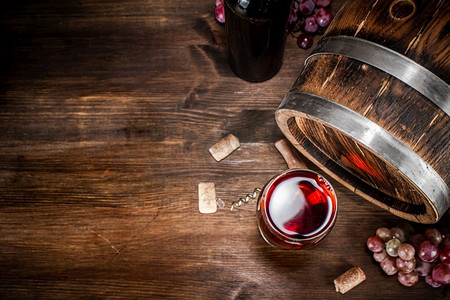红酒装在玻璃桶里。在一个木制的背景。.红酒装在玻璃桶里。 