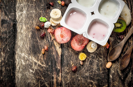 新鲜酸奶配水果和坚果。在一个木制的背景下。新鲜酸奶配水果和坚果。