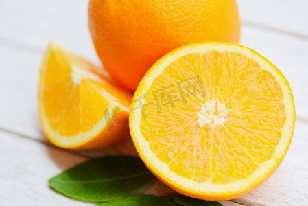 木质背景橙色水果/新鲜橙片半片和橙叶健康水果收获概念