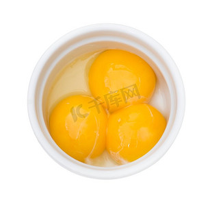 明亮的黄色蛋黄在一个白色碗孤立在白色背景