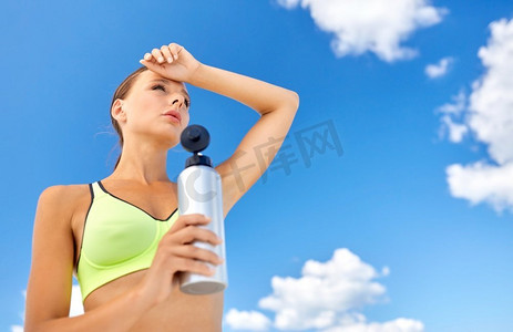 瘦身女子摄影照片_健身、运动和健康的生活方式理念-疲惫的年轻女子在户外喝瓶装水。运动后喝瓶装水的妇女