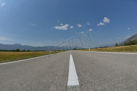 乡村道路沥青线与美丽的自然和晴朗的夏天与蓝天