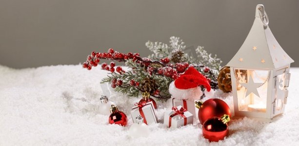 圣诞节假期卡与礼物，球，和白色发光灯笼在雪。圣诞装饰在雪