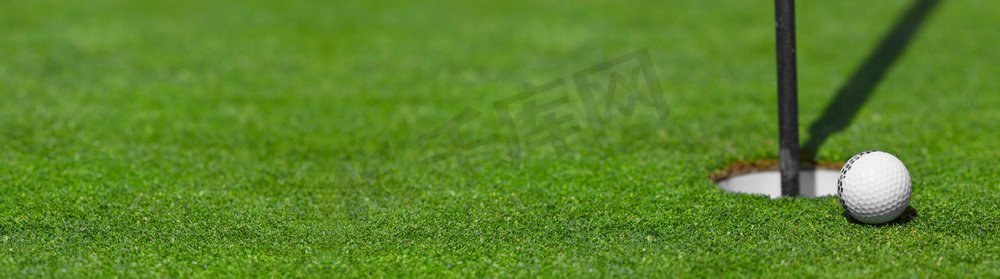 tee摄影照片_高尔夫球在杯球场背景嘴唇与复制空间。高尔夫球杯唇