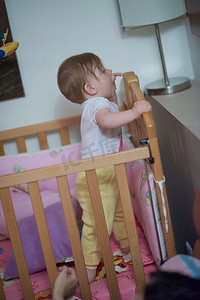 可爱的小一岁的婴儿玩玩具在床上，而使第一步和学习走路