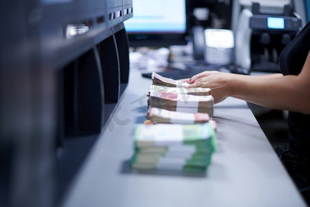 银行职员在银行金库内对纸币进行分类和计数时，使用点钱机。银行里有大量的钱