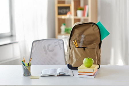 教育和学习理念-书本、苹果和学习用品放在家里的桌子上。书本、苹果和学习用品放在家里的桌子上