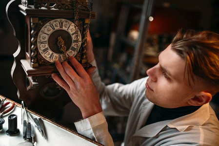 钟表匠在车间里调整旧表的机械装置。钟表匠在工作。制表师调整旧表的机制