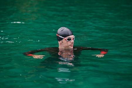 png绿水摄影照片_铁人三项运动员穿着潜水服在绿水湖进行极限晨练
